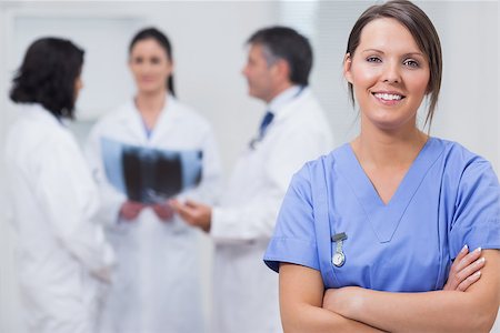 doctor baby looking at camera - Nurse smiling with her team taking xray seriously on background Stock Photo - Budget Royalty-Free & Subscription, Code: 400-06873876