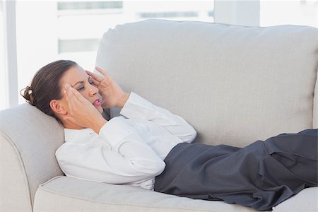 Business woman lying on couch with headache in the office Stock Photo - Budget Royalty-Free & Subscription, Code: 400-06884110