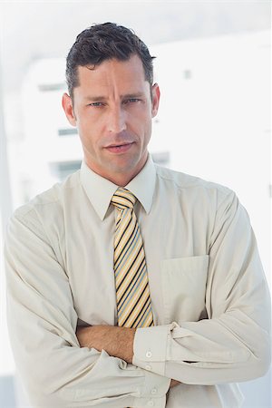 simsearch:400-07274414,k - Businessman with crossed arms looking at camera in office Photographie de stock - Aubaine LD & Abonnement, Code: 400-06884128
