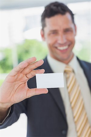 simsearch:400-06879262,k - Happy businessman showing a white business card in office Stock Photo - Budget Royalty-Free & Subscription, Code: 400-06884155