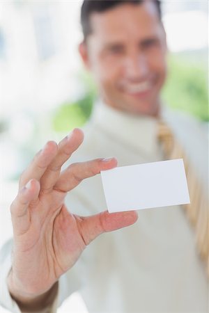 simsearch:400-06879262,k - Happy businessman presenting white business card in office Stock Photo - Budget Royalty-Free & Subscription, Code: 400-06884158