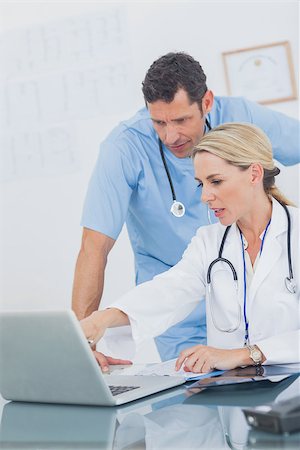 simsearch:6109-06781530,k - Blonde woman showing something on a laptop to her colleague in a medical office Photographie de stock - Aubaine LD & Abonnement, Code: 400-06884196