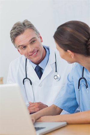 simsearch:6109-06781530,k - Two smiling doctors working on a laptop in a modern office Photographie de stock - Aubaine LD & Abonnement, Code: 400-06884205