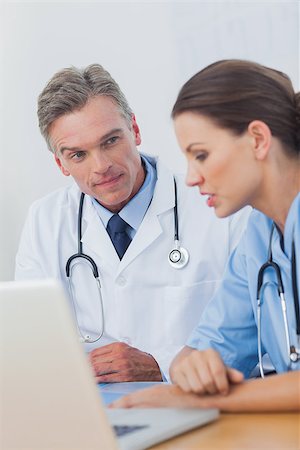 simsearch:6109-06781530,k - Doctor listening attentively to a colleague in a medical office Photographie de stock - Aubaine LD & Abonnement, Code: 400-06884200