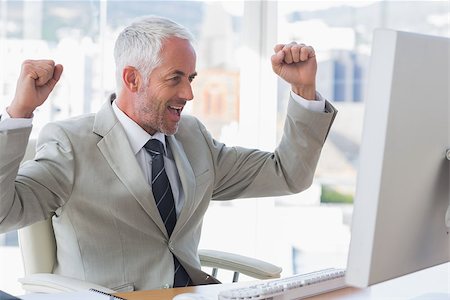 simsearch:6109-08399397,k - Businessman cheering at his desk looking at computer Stock Photo - Budget Royalty-Free & Subscription, Code: 400-06884329