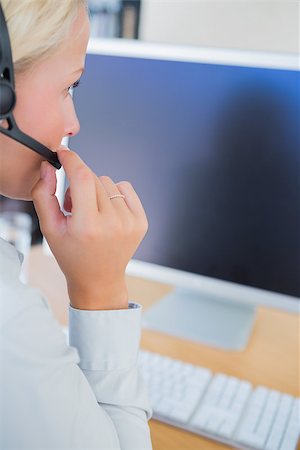 Businesswoman with headset looking at computer at her desk Stock Photo - Budget Royalty-Free & Subscription, Code: 400-06884355