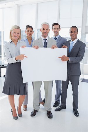 Business team holding large blank poster and smiling at camera in bright office Stock Photo - Budget Royalty-Free & Subscription, Code: 400-06884434