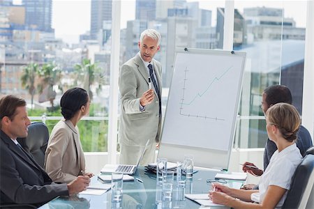 simsearch:400-06879262,k - Serious businessman giving a presentation with colleagues looking at him Stock Photo - Budget Royalty-Free & Subscription, Code: 400-06884485