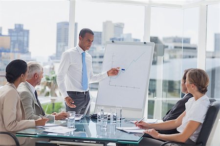 simsearch:400-06879262,k - Manager pointing at a growing chart during a meeting in the meeting room Stock Photo - Budget Royalty-Free & Subscription, Code: 400-06884527