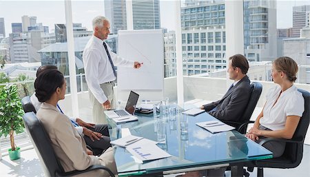 simsearch:400-06879262,k - Manager pointing at a chart during a meeting with all the staff Stock Photo - Budget Royalty-Free & Subscription, Code: 400-06884537