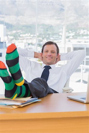 Cheerful businessman relaxing with feet over a pile of documents on his desk Photographie de stock - Aubaine LD & Abonnement, Code: 400-06884547