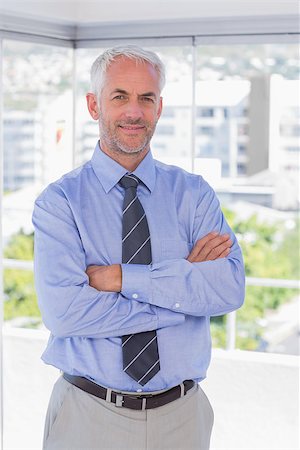 portrait of happy mature businessman standing arms crossed in office - Businessman smiling with arms crossed in his office Stock Photo - Budget Royalty-Free & Subscription, Code: 400-06884811