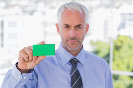 simsearch:400-06879262,k - Businessman showing green business card in his office Stock Photo - Budget Royalty-Free & Subscription, Code: 400-06884824