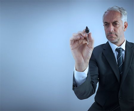 Businessman holding a marker on blue background Stock Photo - Budget Royalty-Free & Subscription, Code: 400-06885016