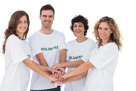Smiling volunteer group piling up their hands on white background Photographie de stock - Aubaine LD & Abonnement, Code: 400-06885194