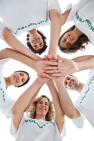 Smiling group of volunteers piling up their hands on white background Photographie de stock - Aubaine LD & Abonnement, Code: 400-06885202