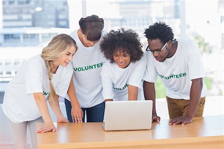 Volunteers working together on a laptop in their office Photographie de stock - Aubaine LD & Abonnement, Code: 400-06885705