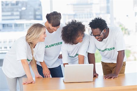 Smiling volunteers working together on a laptop in their office Stock Photo - Budget Royalty-Free & Subscription, Code: 400-06885706