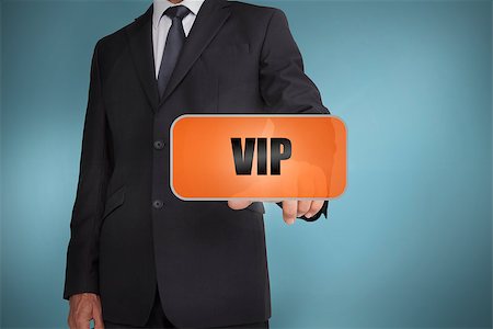 Businessman selecting orange tag with vip written on it on blue background Stock Photo - Budget Royalty-Free & Subscription, Code: 400-06885905