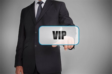 simsearch:400-06886051,k - Businessman selecting tag with vip written on it on grey background Stock Photo - Budget Royalty-Free & Subscription, Code: 400-06885912