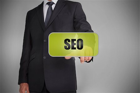 simsearch:400-06886051,k - Businessman selecting green tag with the word seo written on it on grey background Stock Photo - Budget Royalty-Free & Subscription, Code: 400-06885944