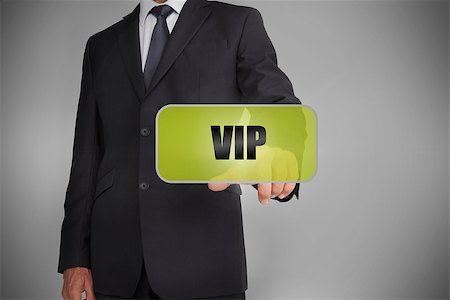 simsearch:400-06886051,k - Businessman selecting green tag with the word vip written on it on grey background Stock Photo - Budget Royalty-Free & Subscription, Code: 400-06885941