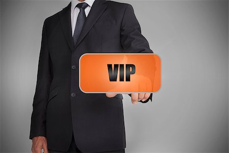 simsearch:400-06886051,k - Businessman touching orange tag with the word vip written on it on grey background Stock Photo - Budget Royalty-Free & Subscription, Code: 400-06885950