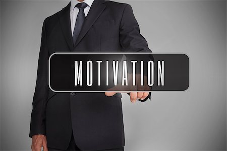 simsearch:400-06886051,k - Businessman selecting the word motivation written on black tag on grey background Stock Photo - Budget Royalty-Free & Subscription, Code: 400-06886025