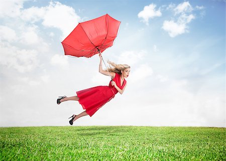 simsearch:649-03883202,k - Beautiful woman flying above the grass with a broken umbrella Stock Photo - Budget Royalty-Free & Subscription, Code: 400-06886219