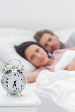 Tired couple lying in their bed next to an alarm clock Stock Photo - Budget Royalty-Free & Subscription, Code: 400-06886255