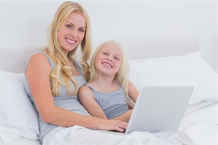 Mother and daughter using a laptop together in bed Stock Photo - Budget Royalty-Free & Subscription, Code: 400-06886519