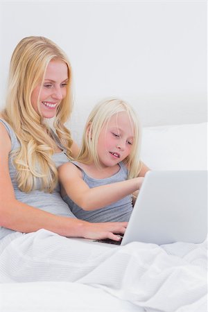 Mom and daughter using a laptop in bed Stock Photo - Budget Royalty-Free & Subscription, Code: 400-06886522