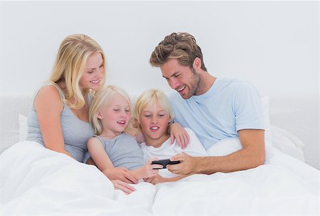 simsearch:400-06872329,k - Beautiful family using a smartphone in bed Foto de stock - Super Valor sin royalties y Suscripción, Código: 400-06886582