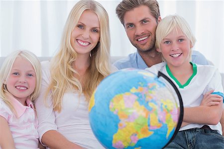 Family sitting on couch holding globe in the living room Stock Photo - Budget Royalty-Free & Subscription, Code: 400-06886626