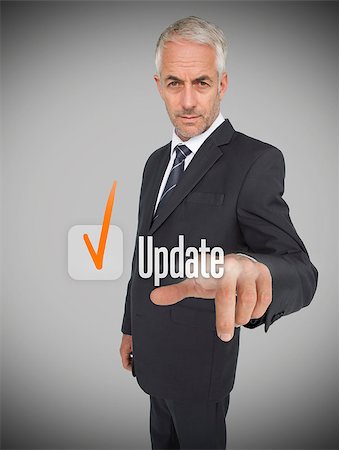 simsearch:400-06886806,k - Businessman selecting the word update next to a ticked box Photographie de stock - Aubaine LD & Abonnement, Code: 400-06886783