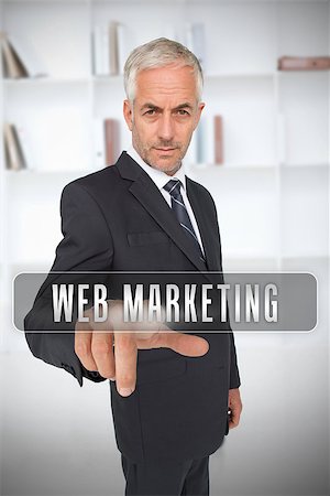 simsearch:400-06886789,k - Businessman touching the term web marketing in front of a bookcase Stock Photo - Budget Royalty-Free & Subscription, Code: 400-06886806