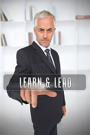 simsearch:400-06886798,k - Serious businessman touching the term learn and lead in front of a bookcase Stock Photo - Budget Royalty-Free & Subscription, Code: 400-06886801