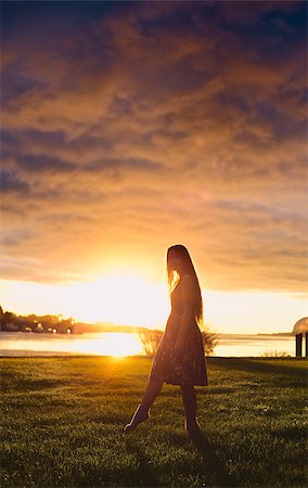 sun halo - beautiful girl standing on river shore in rays of setting sun Photographie de stock - Aubaine LD & Abonnement, Code: 400-06886941