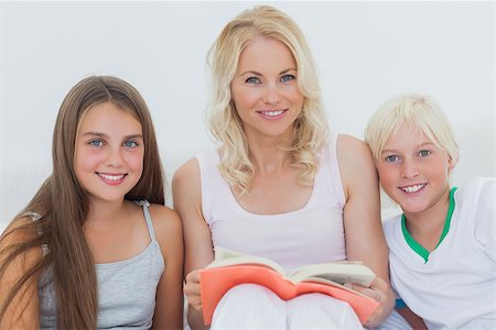 Portrait of mother holding a storybook to her happy children Stock Photo - Budget Royalty-Free & Subscription, Code: 400-06887644