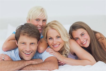 Smiling family lying together on bed Stock Photo - Budget Royalty-Free & Subscription, Code: 400-06887664