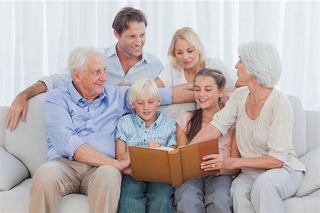 family photos in album - Extended cheerful family looking at a photo album in living room Stock Photo - Budget Royalty-Free & Subscription, Code: 400-06887773