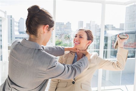 strangle women - Businesswoman strangling her partner holding a shoe in bright office Stock Photo - Budget Royalty-Free & Subscription, Code: 400-06887864