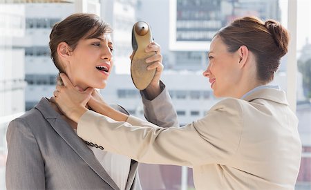 strangle women - Businesswoman defending herself from her colleague strangling her in a bright office Stock Photo - Budget Royalty-Free & Subscription, Code: 400-06887860