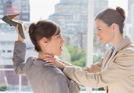 strangle women - Businesswoman defending herself from her co worker strangling her in a bright office Stock Photo - Budget Royalty-Free & Subscription, Code: 400-06887861