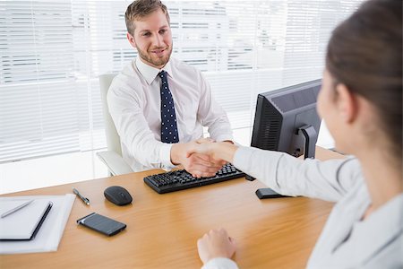 Businessman shaking hands with a colleague at his desk in the office Stock Photo - Budget Royalty-Free & Subscription, Code: 400-06887948