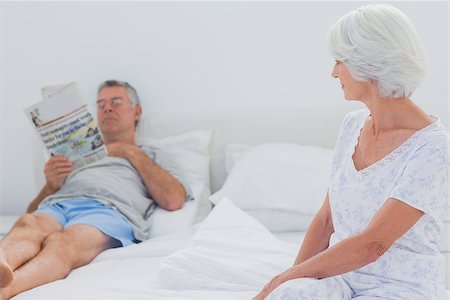simsearch:400-06888132,k - Woman looking at husband reading newspaper in the bed Photographie de stock - Aubaine LD & Abonnement, Code: 400-06888133