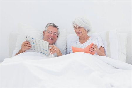 simsearch:400-06888132,k - Mature man showing newspaper to his wife in bed Photographie de stock - Aubaine LD & Abonnement, Code: 400-06888141