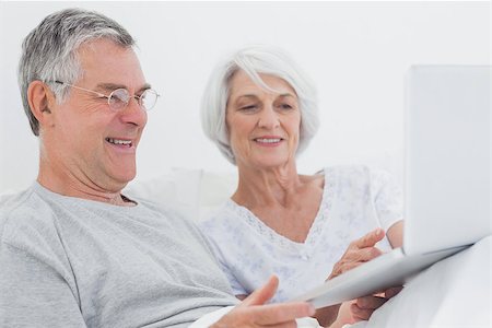 Mature couple using a laptop together in bed Stock Photo - Budget Royalty-Free & Subscription, Code: 400-06888156