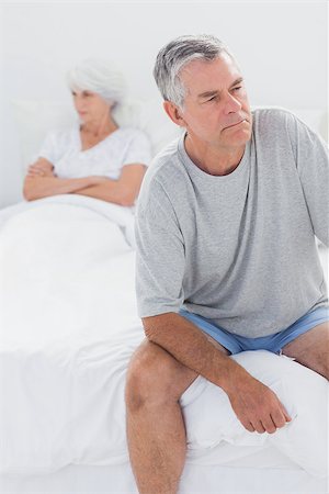 simsearch:400-06888132,k - Upset man sitting on bed during a dispute with wife with arms crossed Photographie de stock - Aubaine LD & Abonnement, Code: 400-06888161