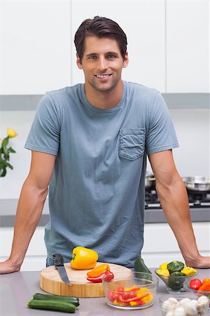 simsearch:400-06061963,k - Attractive man standing in his kitchen in front of sliced vegetables Foto de stock - Royalty-Free Super Valor e Assinatura, Número: 400-06888312